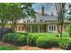 Expansive brick home features a lush backyard, covered patio, and manicured landscaping at 5701 Challisford Ln, Charlotte, NC 28226
