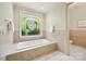 Bathroom featuring a tub with tile surround and a stained glass window at 5701 Challisford Ln, Charlotte, NC 28226