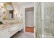 Elegant bathroom featuring a marble countertop vanity, a large mirror, and a shower at 5701 Challisford Ln, Charlotte, NC 28226