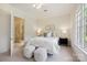 Cozy bedroom with white bedding, dark furniture, and an attached bathroom at 5701 Challisford Ln, Charlotte, NC 28226