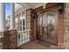 Close-up of an ornate wrought iron front door with brick and stone accents and a covered porch at 6164 Dwayne Starnes Dr, Hickory, NC 28602