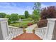 View of landscaped front yard from stairs, showcasing a curved walkway, lush greenery, and flowering plants at 6164 Dwayne Starnes Dr, Hickory, NC 28602