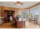 Well-lit office featuring custom built-ins, a large desk, and bright windows showcasing the landscaped yard at 6164 Dwayne Starnes Dr, Hickory, NC 28602