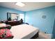 Bedroom showcasing blue walls, a bed, dresser, and window with natural light at 6614 Wicked Oak Ln, Charlotte, NC 28216