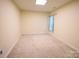 Cozy bedroom with carpet, neutral walls, window with curtains, and ample natural light at 6614 Wicked Oak Ln, Charlotte, NC 28216