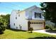 Exterior view of a two-story white home with a lush green lawn and a well-manicured garden at 6614 Wicked Oak Ln, Charlotte, NC 28216