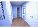 Hallway with blue walls, wood floors, and multiple white doors, leading to various rooms in the house at 6614 Wicked Oak Ln, Charlotte, NC 28216