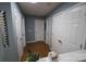 Hallway featuring wood floors, blue walls, multiple doors, and a decorative mirror at 6614 Wicked Oak Ln, Charlotte, NC 28216