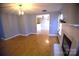 Well-lit living room featuring hardwood floors, a fireplace, and a modern lighting fixture at 6614 Wicked Oak Ln, Charlotte, NC 28216