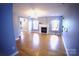 Comfortable living room with hardwood floors, a fireplace, and natural light from large windows at 6614 Wicked Oak Ln, Charlotte, NC 28216