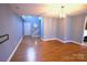 Open living area with hardwood floors leading to the staircase and entrance, brightened by natural light at 6614 Wicked Oak Ln, Charlotte, NC 28216