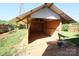Backyard shed with a covered roof and exposed beams, surrounded by green grass at 6614 Wicked Oak Ln, Charlotte, NC 28216