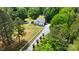 Aerial view of the home, surrounded by trees and a long driveway lined with white fence at 6910 Birdsong Ln, Waxhaw, NC 28173