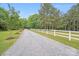 Gravel driveway lined with white fencing and mature trees at 6910 Birdsong Ln, Waxhaw, NC 28173