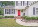 Inviting front entrance with a red door, brick steps, and landscaped garden beds at 6910 Birdsong Ln, Waxhaw, NC 28173