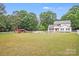 Expansive green yard with a white fence around a two-story home and a small barn at 6910 Birdsong Ln, Waxhaw, NC 28173