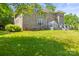 Exterior shot of the home's back brick facade and yard, including deck, landscaping, and beautiful lawn at 7365 Gabriel St, Sherrills Ford, NC 28673