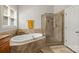 Bathroom featuring a soaking tub with tile surround, walk-in shower, and natural light from the window at 7365 Gabriel St, Sherrills Ford, NC 28673