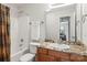Bathroom featuring a shower-tub combo, granite counters, and sink with wood cabinets at 7365 Gabriel St, Sherrills Ford, NC 28673
