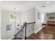 Staircase with wood floors and railing, leading to an upstairs hallway with artwork and natural light at 7365 Gabriel St, Sherrills Ford, NC 28673