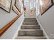 Carpeted staircase with gray walls and white trim, accented by framed artwork on the wall at 7365 Gabriel St, Sherrills Ford, NC 28673