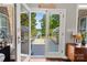 Inviting view from indoors through glass doors to deck and beyond to lake, with sign 