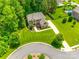 Aerial view of a stately brick home with lush landscaping and a circular driveway in a serene, wooded setting at 801 Hidden Pond Ln, Waxhaw, NC 28173