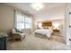 Cozy bedroom featuring a modern wood headboard, soft lighting, and a comfortable chair by the bright window at 801 Hidden Pond Ln, Waxhaw, NC 28173