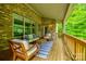 Inviting covered porch features wood furniture and brick accents, perfect for outdoor relaxation and entertaining at 801 Hidden Pond Ln, Waxhaw, NC 28173