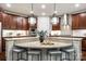 A kitchen island features stone countertops, seating, and pendant lights, enhancing style and functionality at 801 Hidden Pond Ln, Waxhaw, NC 28173