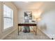 Bright home office with a modern desk, comfortable chair, and natural light from the window, perfect for productivity at 801 Hidden Pond Ln, Waxhaw, NC 28173