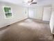 Spacious bedroom with neutral carpet, a ceiling fan, and a large window at 8049 Regent Park Ln, Charlotte, NC 28210