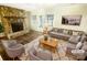 Inviting living room featuring a stone fireplace, modern furniture, and ample natural light from the windows at 8049 Regent Park Ln, Charlotte, NC 28210