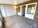 Covered patio with brick flooring, multiple windows, and access to the house and backyard at 8049 Regent Park Ln, Charlotte, NC 28210