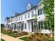 Beautiful townhomes with white siding, black shutters and manicured landscaping provide great curb appeal at 8114 Jacey Ln # 21, Huntersville, NC 28078