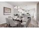 Stylishly staged dining room features a glass table with seating for six, with the kitchen in the background at 8118 Jacey Ln # 21, Huntersville, NC 28078