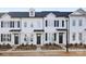 Charming townhome showcases a sleek white exterior, black shutters, and meticulously manicured landscaping at 8118 Jacey Ln # 21, Huntersville, NC 28078