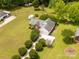 Overhead shot of a well-maintained brick home with a green lawn, outbuildings, and mature trees at 819 Riddle Mill Rd, Clover, SC 29710