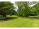 Expansive backyard featuring a lush lawn, mature trees, and a swing, creating a serene outdoor space at 819 Riddle Mill Rd, Clover, SC 29710