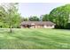 Ranch-style home featuring a brick facade, shutters, and a spacious lawn with mature trees at 856 Skyline Dr, Chester, SC 29706