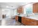 Bright kitchen features wood cabinets, stainless steel sink, black dishwasher, and gray vinyl flooring at 856 Skyline Dr, Chester, SC 29706