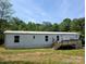 Exterior view of a single-story home featuring a wooden deck, modest landscaping, and a clean white exterior at 874 Old Home Place Way, Lincolnton, NC 28092