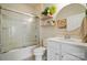 Bright bathroom with a tub-shower combo, decorative shelves, round mirror, and white vanity with drawers and cabinet doors at 9003 Smokey Hill Ln, Fort Mill, SC 29707