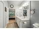 Bathroom with double sink vanity, wood-look tile floors, and view into a connecting bedroom, creating a functional space at 9003 Smokey Hill Ln, Fort Mill, SC 29707