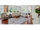 Spacious living room featuring large windows, a cozy sectional, and hardwood flooring at 9003 Smokey Hill Ln, Fort Mill, SC 29707