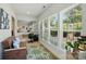 Bright sunroom with large windows, a comfortable seating area, and an adjacent workspace, perfect for relaxation and productivity at 9003 Smokey Hill Ln, Fort Mill, SC 29707