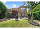 Beautiful backyard featuring a brick patio, outdoor seating, lush greenery, and a well-maintained lawn at 9735 Wheatfield Rd, Charlotte, NC 28277