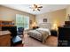 A cozy bedroom with neutral colored walls, complemented by comfortable furniture and a large window at 9735 Wheatfield Rd, Charlotte, NC 28277