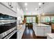 Gourmet kitchen with an island, stainless steel appliances, granite counters, white cabinets and seamless access to the dining area at 9735 Wheatfield Rd, Charlotte, NC 28277