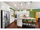 Bright kitchen with a center island, stainless steel appliances and an adjacent dining area and refrigerator at 9735 Wheatfield Rd, Charlotte, NC 28277